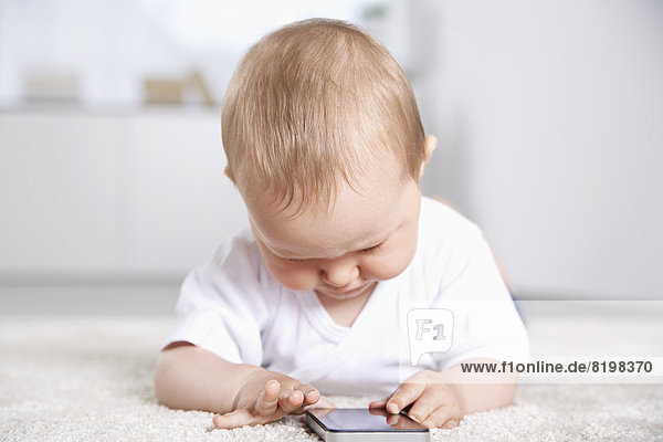 Deutschland  Nordrhein-Westfalen    Baby Mädchen spielt mit Handy