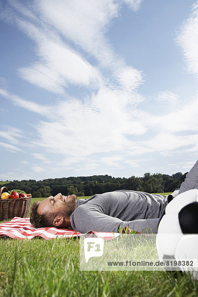 Mann entspannt auf Picknickdecke