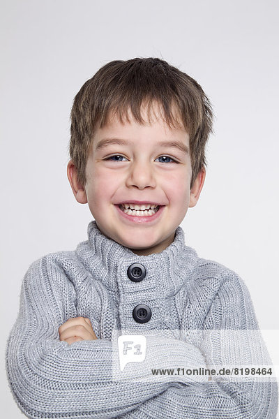 Portrait of boy against white background,  smiling