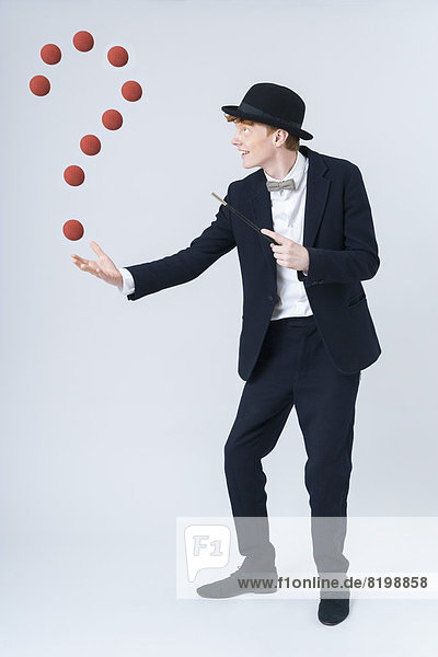 Young man showing magic with ball  smiling