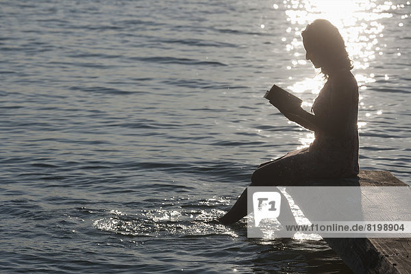 Reife Frau beim Lesen am Stamberger See