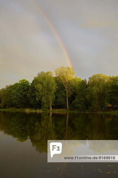 Germany  Schleswig Holstein  View of rainbow near Little lake at dusk