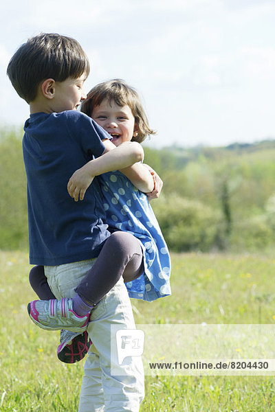Young siblings embracing outdoors