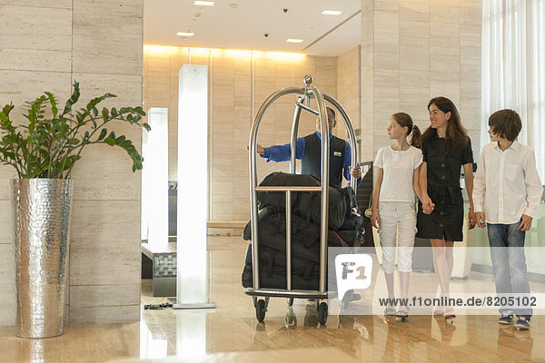 Bellhop für Mutter und Kinder mit Gepäck in der Hotellobby