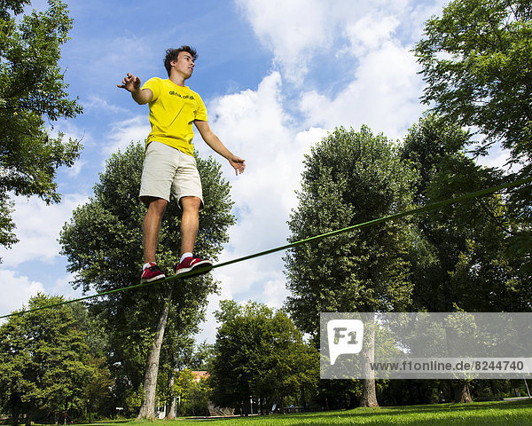 Junger Mann auf einer Slackline