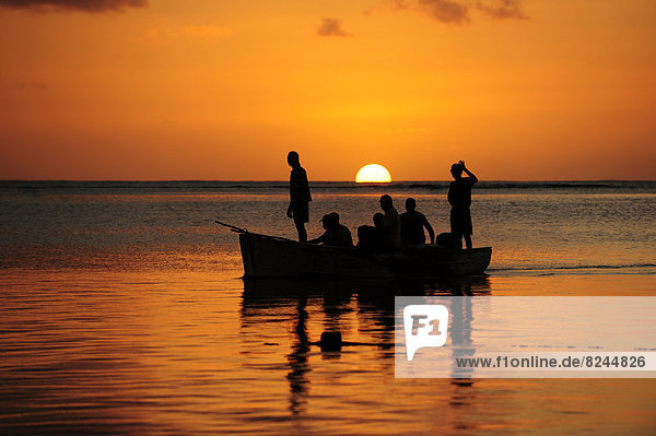 Fishermen on a boat at sunset