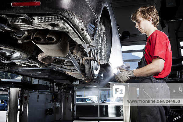 Car mechanic changing tyres in a car repair shop