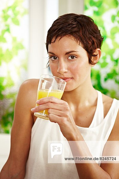 Portrait of woman holding glass of juice