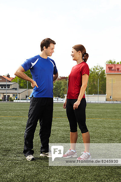 Portrait of female and male athletes standing on field