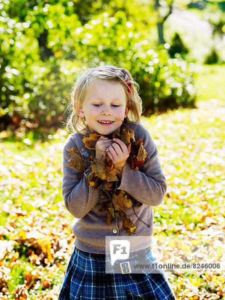 Girl holding autumn leaves