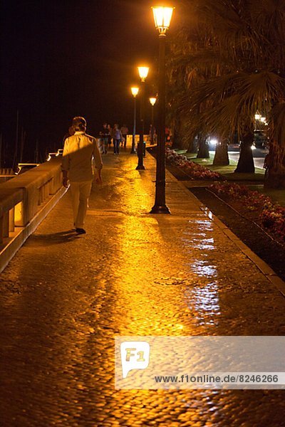 People walking on promenade at night  Portugal