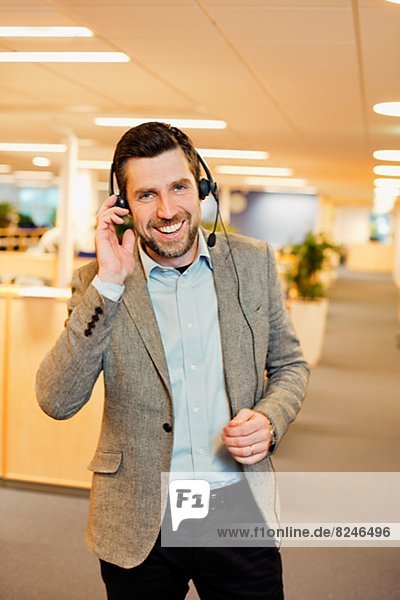 Portrait of young businessman in office with headset