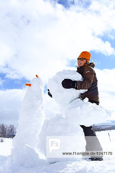 Woman building snowman