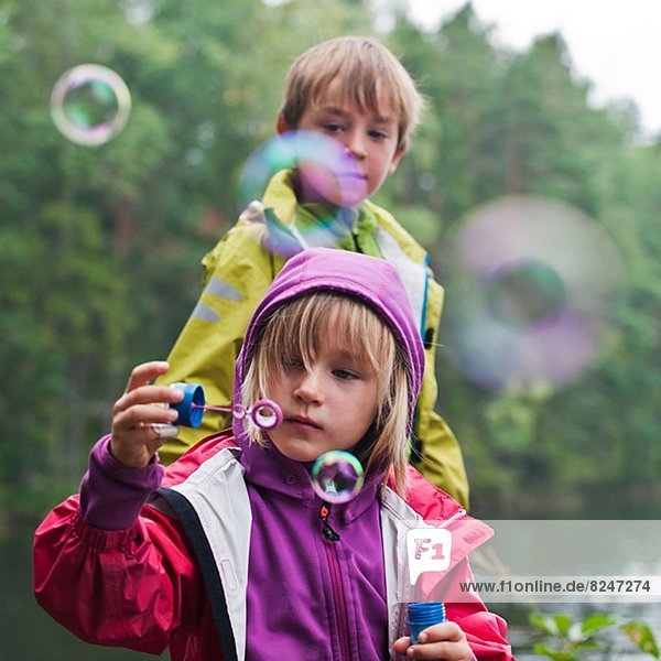 Außenaufnahme  Junge - Person  blasen  bläst  blasend  Blase  Blasen  Hintergrund  Mädchen  freie Natur