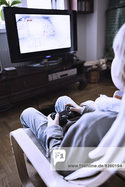 Kleiner Junge spielt Videospiel im Fernsehen zu Hause