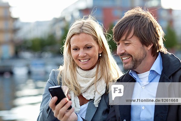 Couple using cell phone together