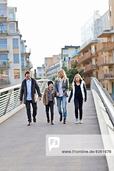 Family with two kids walking on footbridge