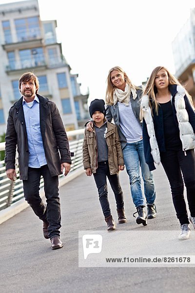 Family with two kids walking on footbridge