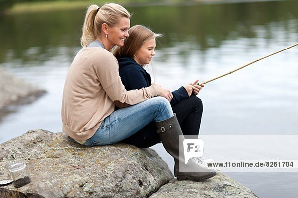 Daughter and mother fishing at lake