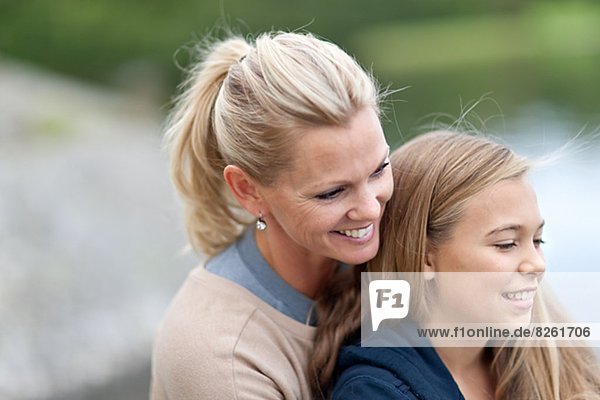 Mother embracing daughter outdoors