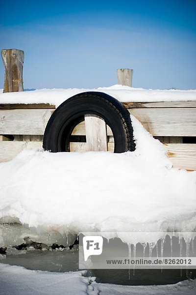 Car tire on jetty at winter