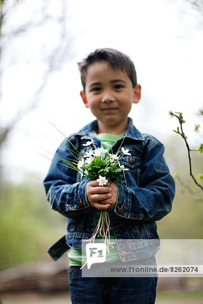 Smiling boy holding flowers