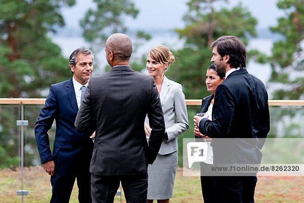 Businessmen and businesswomen discussing outdoors