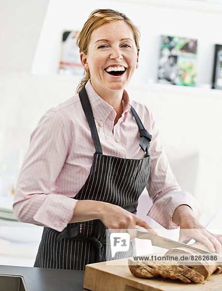 Frau  lächeln  Brot  schneiden  Küche