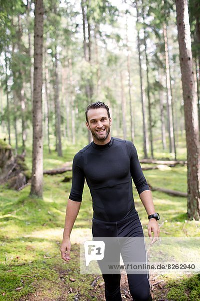 Mid adult man jogging in forest