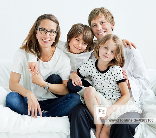 Happy family sitting on sofa  studio shot