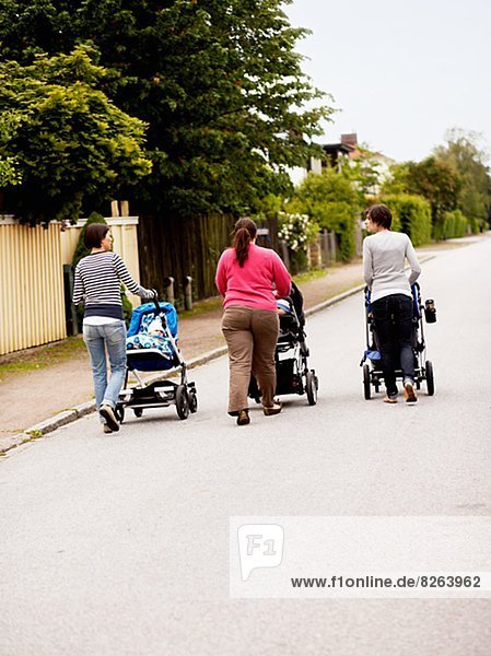 Women walking with baby carriages,  Sweden.