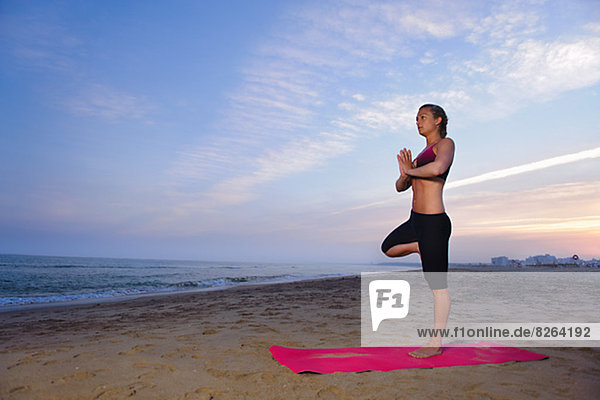 Women doing yoga on beach