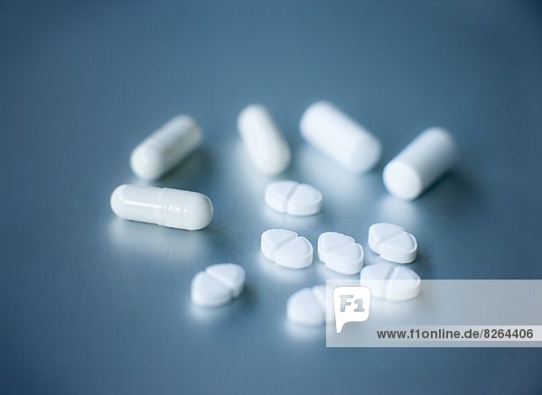 Pills and capsules on grey background