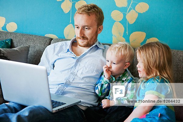 Vater mit Tochter und Sohn mit laptop