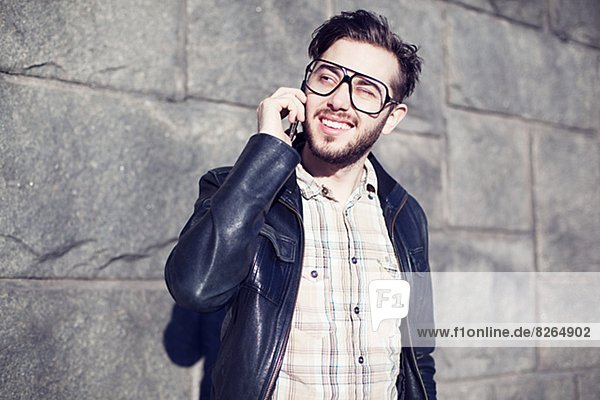Smiling young man talking via cell phone
