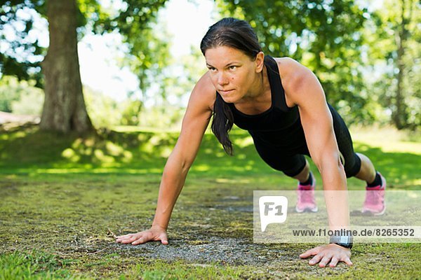 Woman doing push-ups in garden