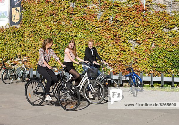 Smiling university students cycling