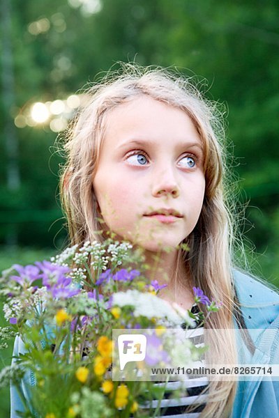 Portrait of girl holding wildflowers