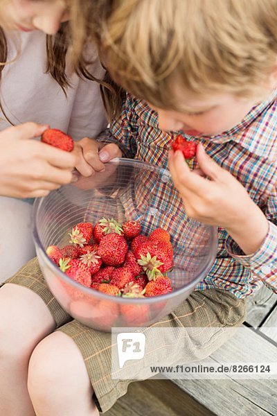 Boy and girl eating strawberry