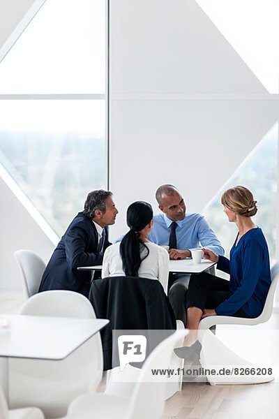 Businessman and businesswomen talking while drinking coffee