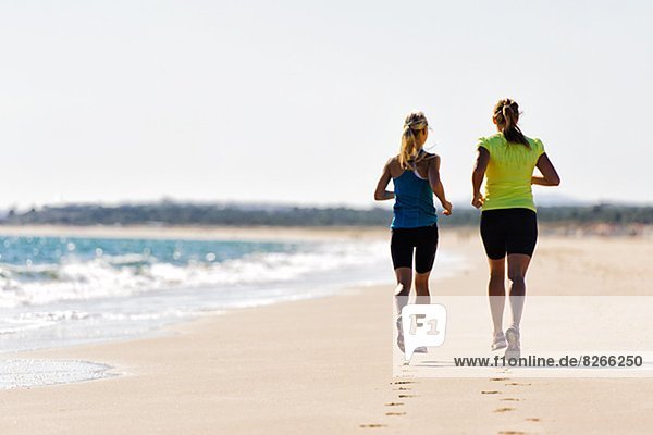 Young women running on beach  Algarve  Portugal