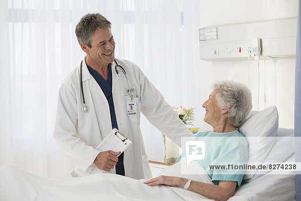 Doctor talking to elderly patient in hospital