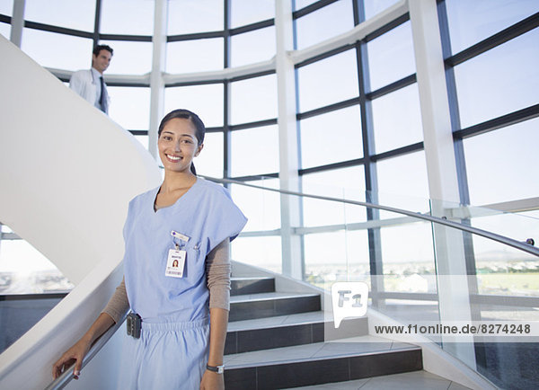 Portrait of smiling nurse on stairs