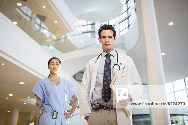 Porträt des selbstbewussten Arztes und der Krankenschwester im Krankenhausatrium