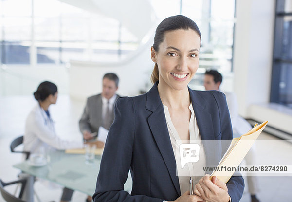Portrait of smiling businesswoman in meeting with doctors
