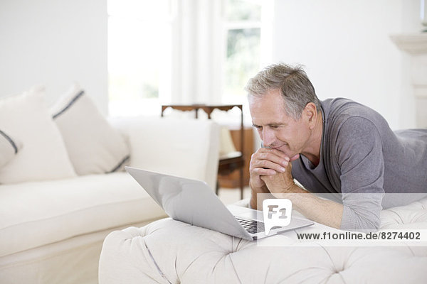 Senior man using laptop in livingroom