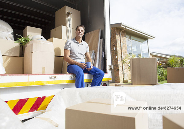 Man sitting in moving truck in driveway