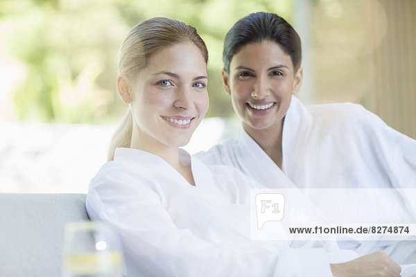 Portrait of smiling women in bathrobes at spa