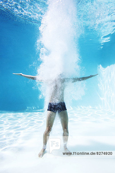Mann steht unter Wasser im Schwimmbad