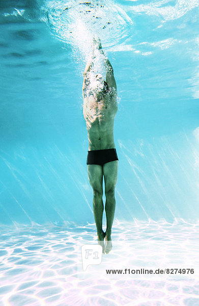 Mann unter Wasser im Schwimmbad
